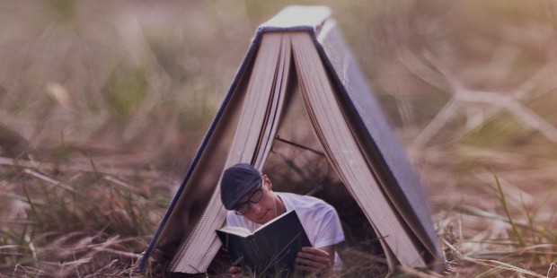 boy reading a book under a tent card