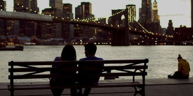 couple sitting on a bench by the river