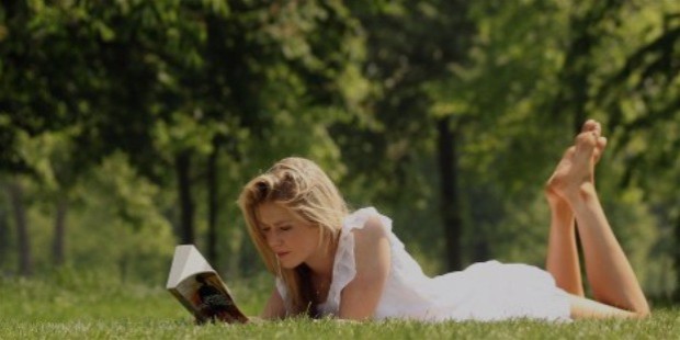 girl reading book field