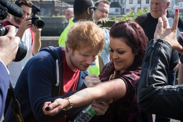Ed Shareen Signing His Autograph on a Fan's Arm