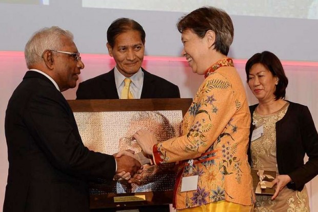 Mr S. Dhanabalan being presented with a picture mosiac By Ho Ching