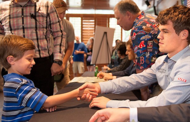 Carlsen shaking hands with a little fan
