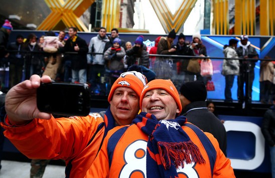 Todd Barnes and Mitch Daniels photograph themselves on Super Bowl Boulevard