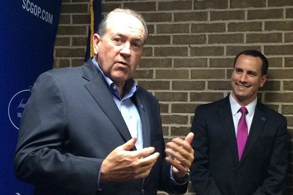 Mike Huckabee (left) speaks with reporters from the South Carolina Republican