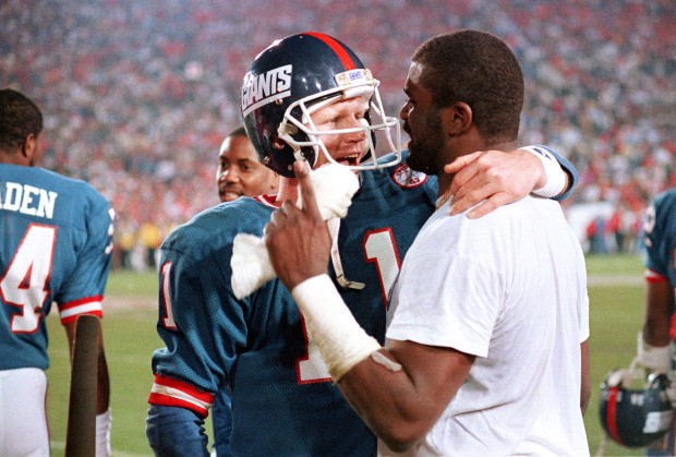 Phil Simms embraces linebacker Lawrence Taylor